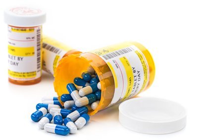 Prescription pill bottles with spilled capsules — opioid and stimulant treatment for professionals
